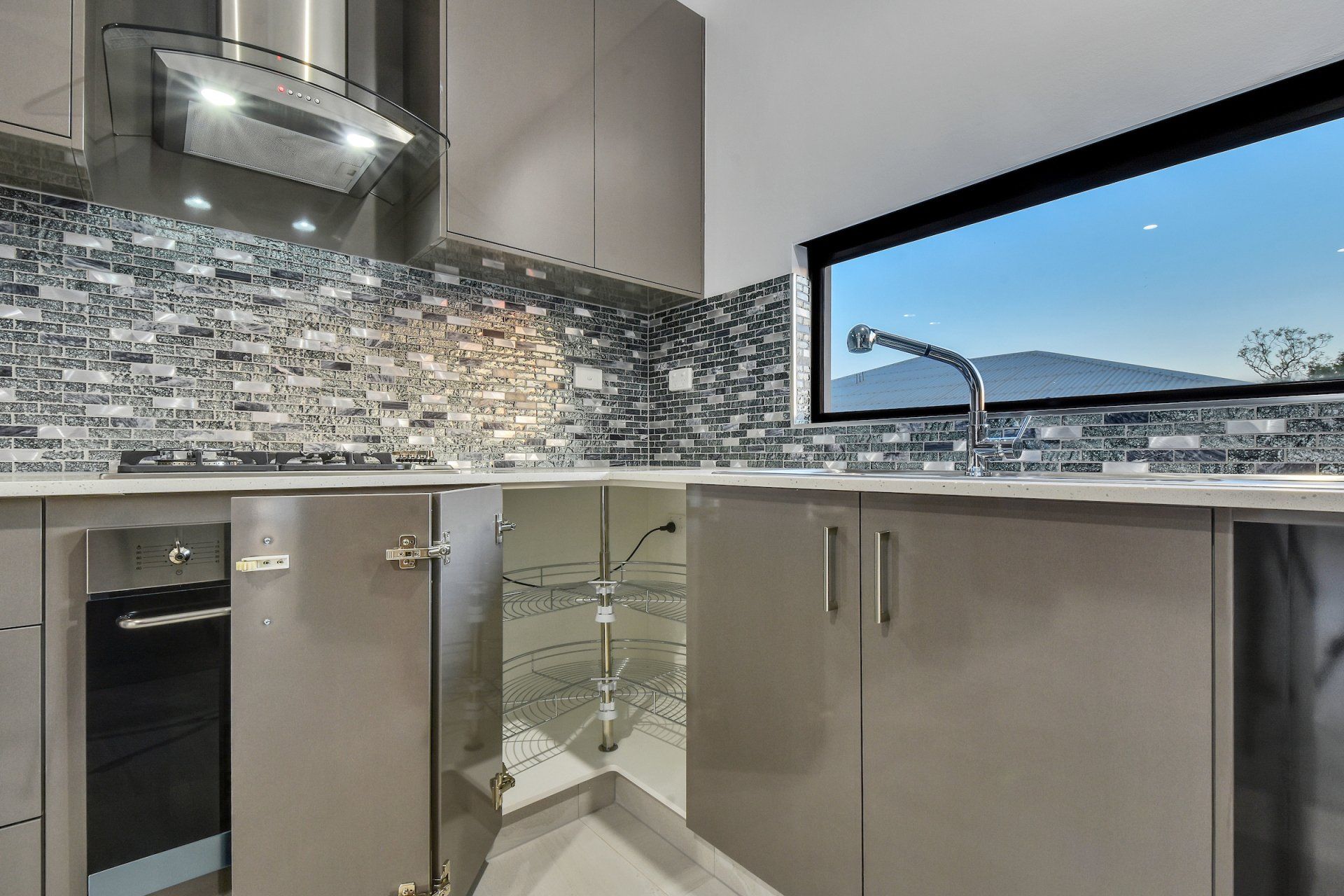 A kitchen with stainless steel appliances and a large window.