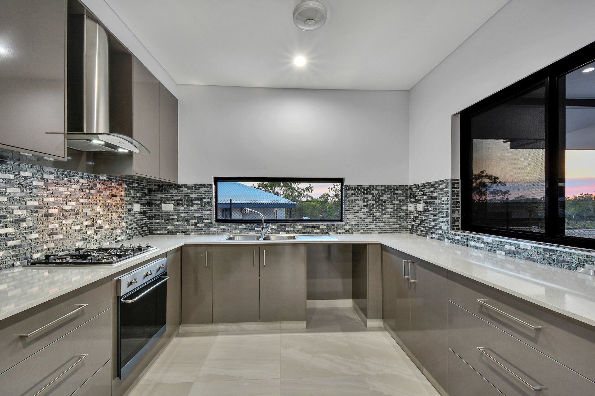 A kitchen with stainless steel appliances and a large window