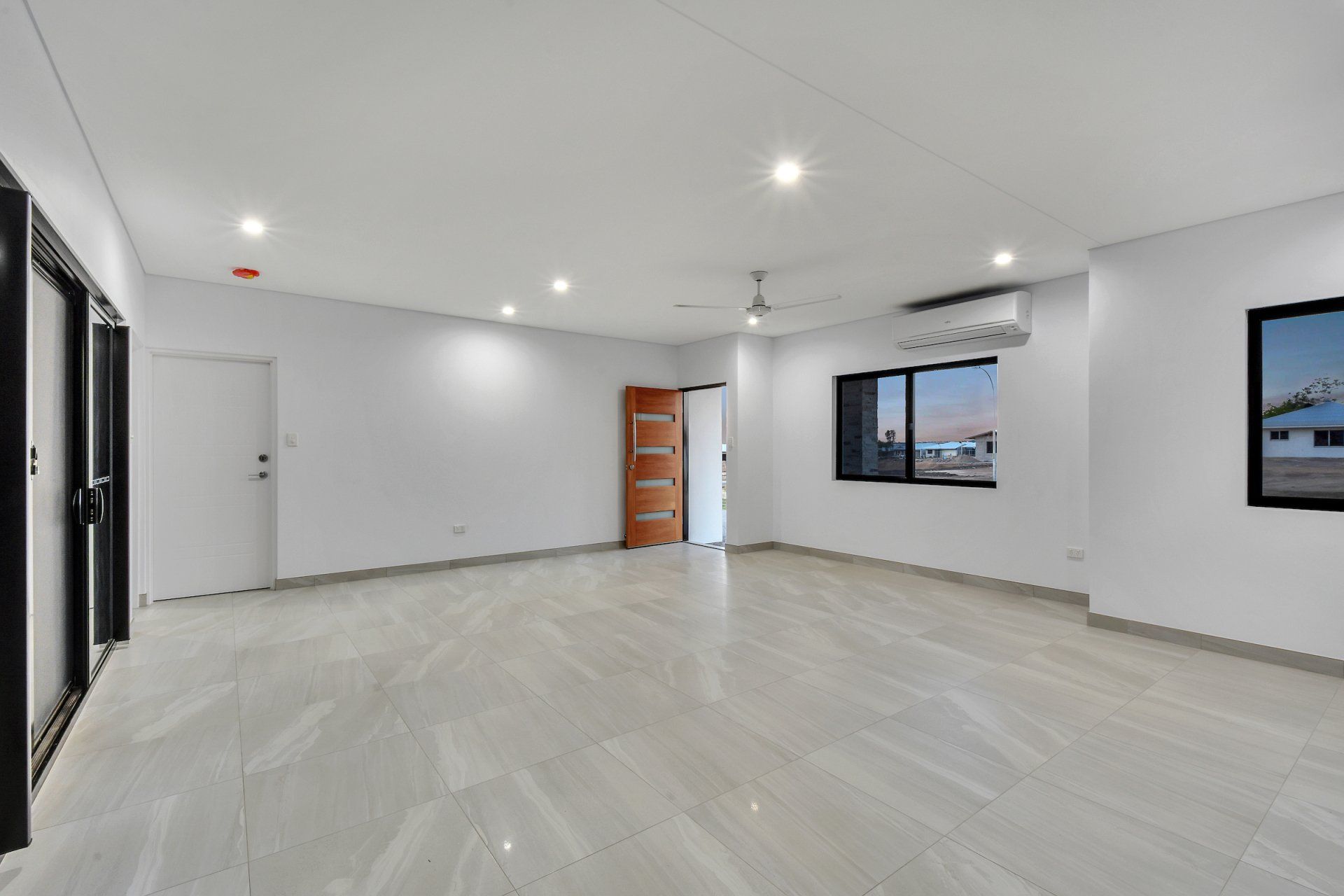 A large empty room with white walls and a wooden floor.