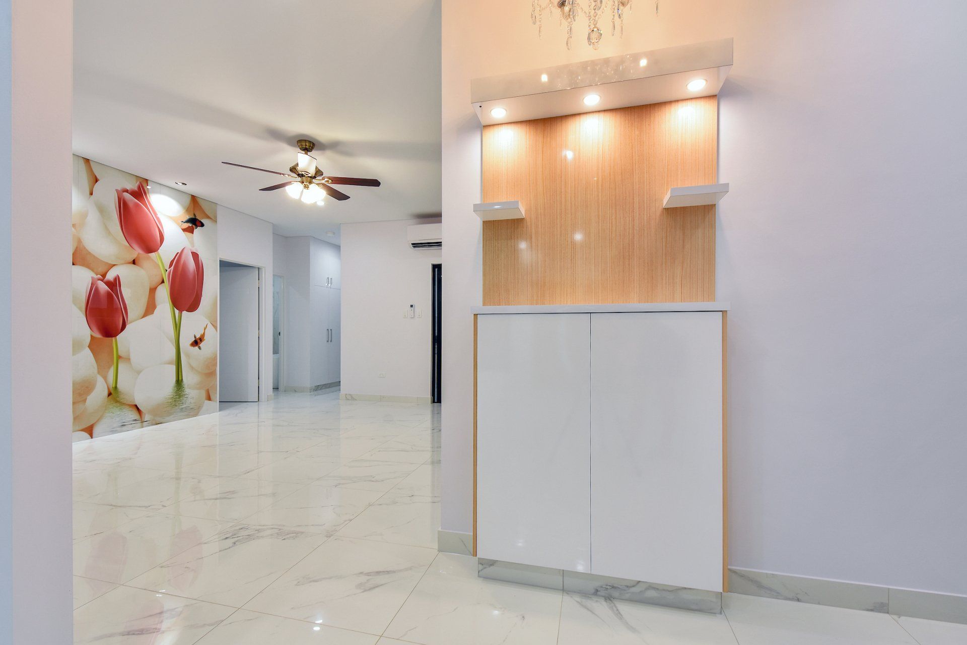 A living room with a ceiling fan and a painting on the wall.