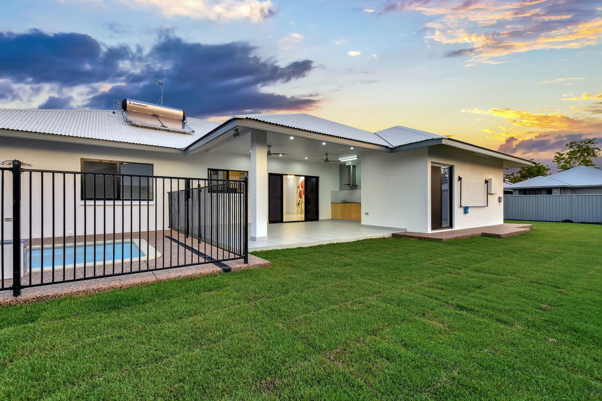 The backyard of a house with a fence and a pool.