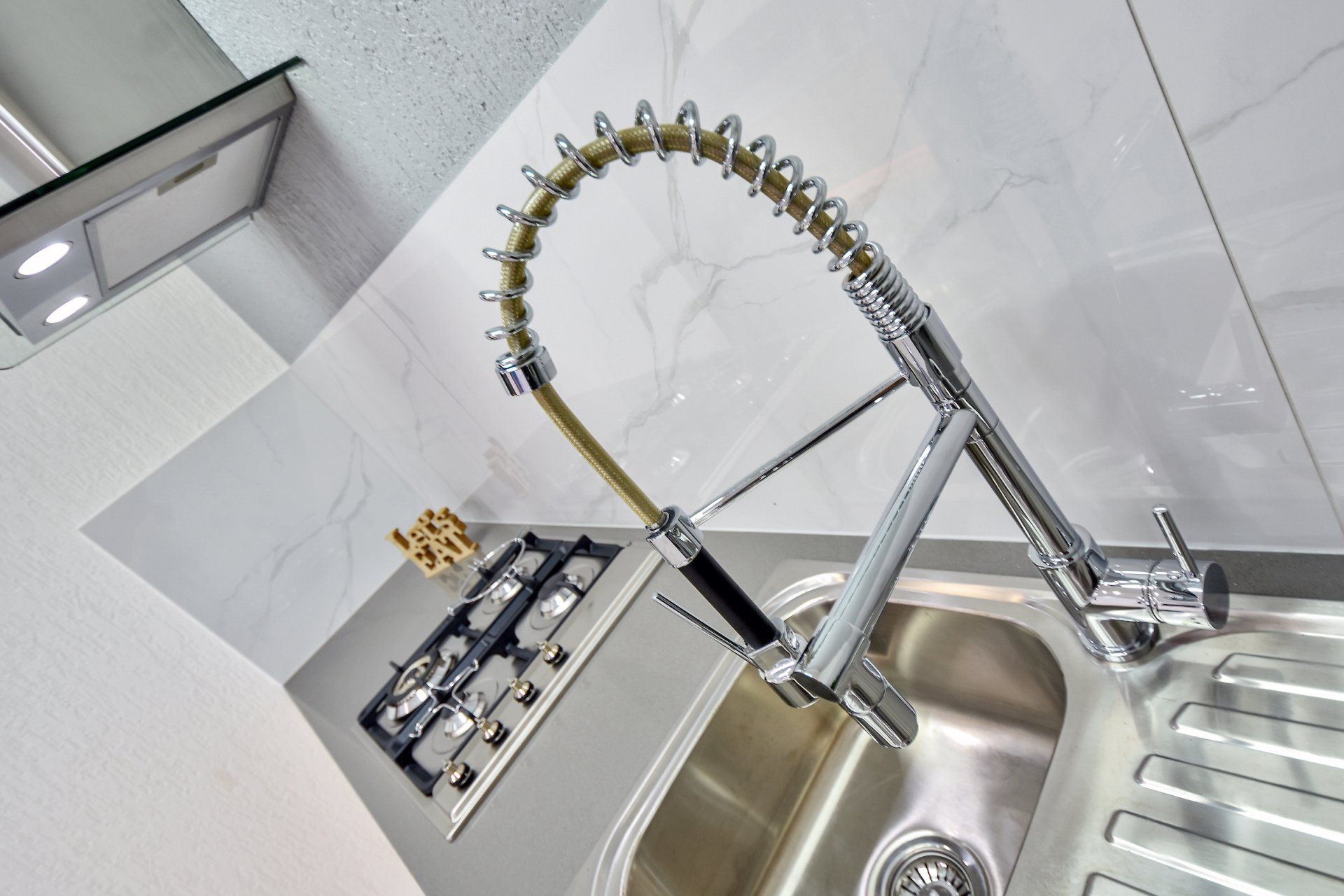 A kitchen sink with a stainless steel faucet