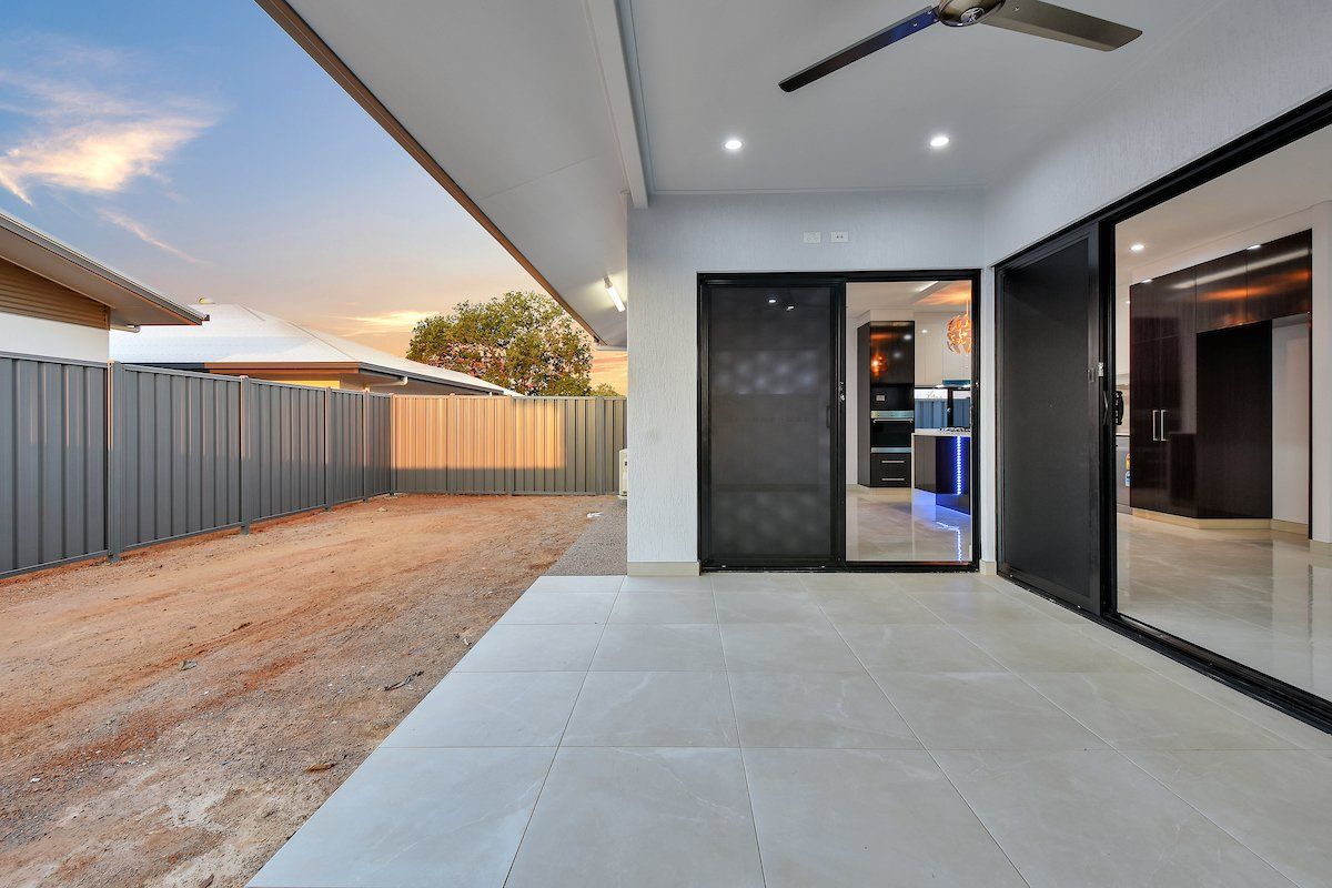 A patio with a sliding glass door and a ceiling fan in a house.
