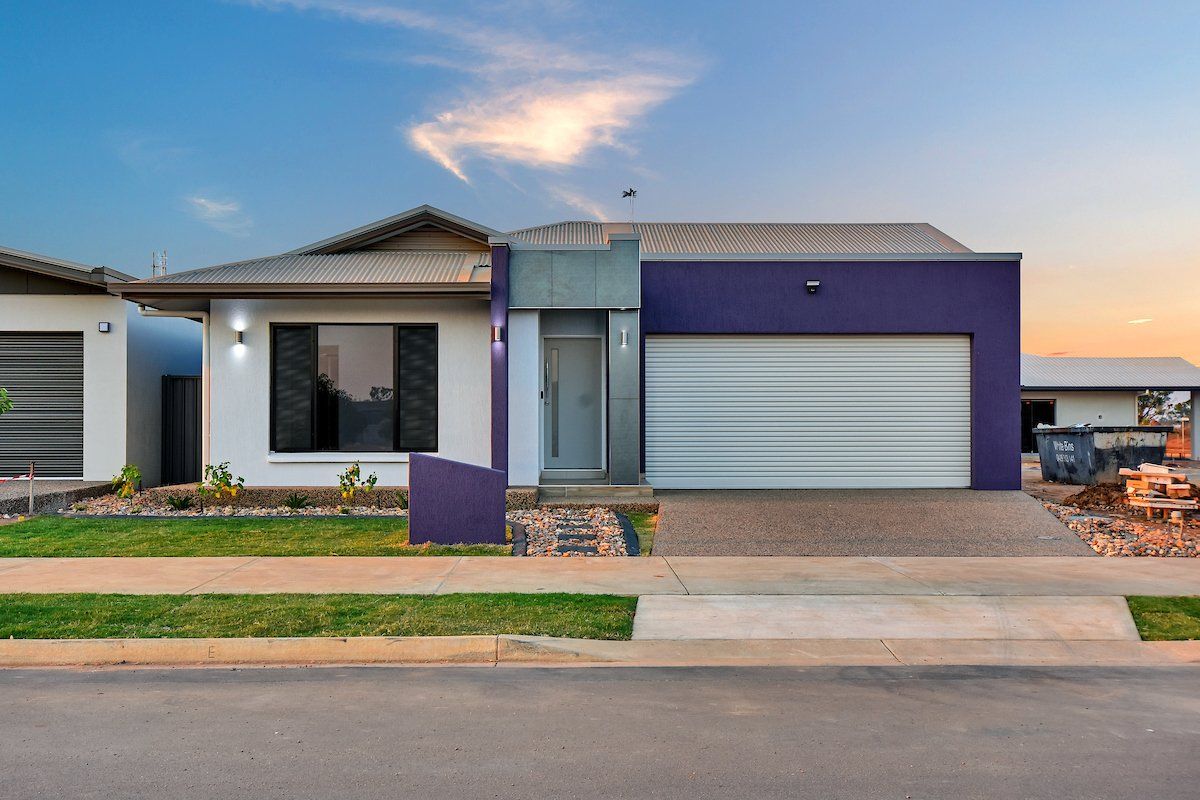 A white house with purple trim and a purple garage door