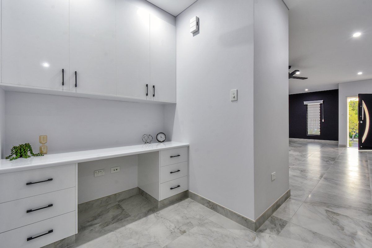 There is a desk in the corner of the room.