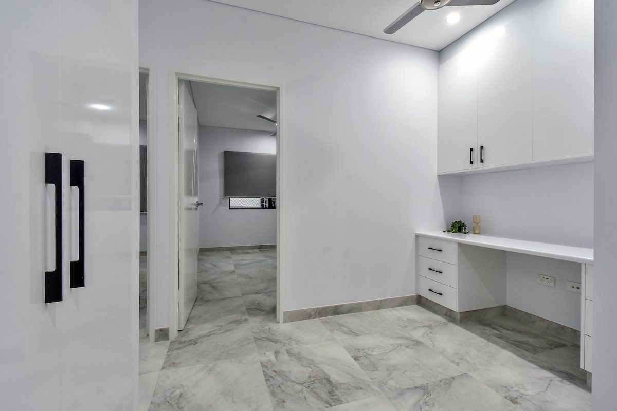 An empty room with a ceiling fan and a desk.