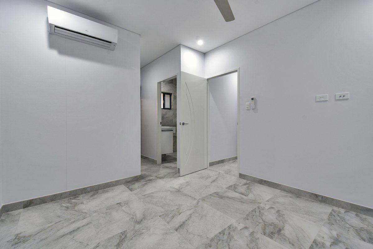 An empty room with a ceiling fan and a door leading to a bathroom.