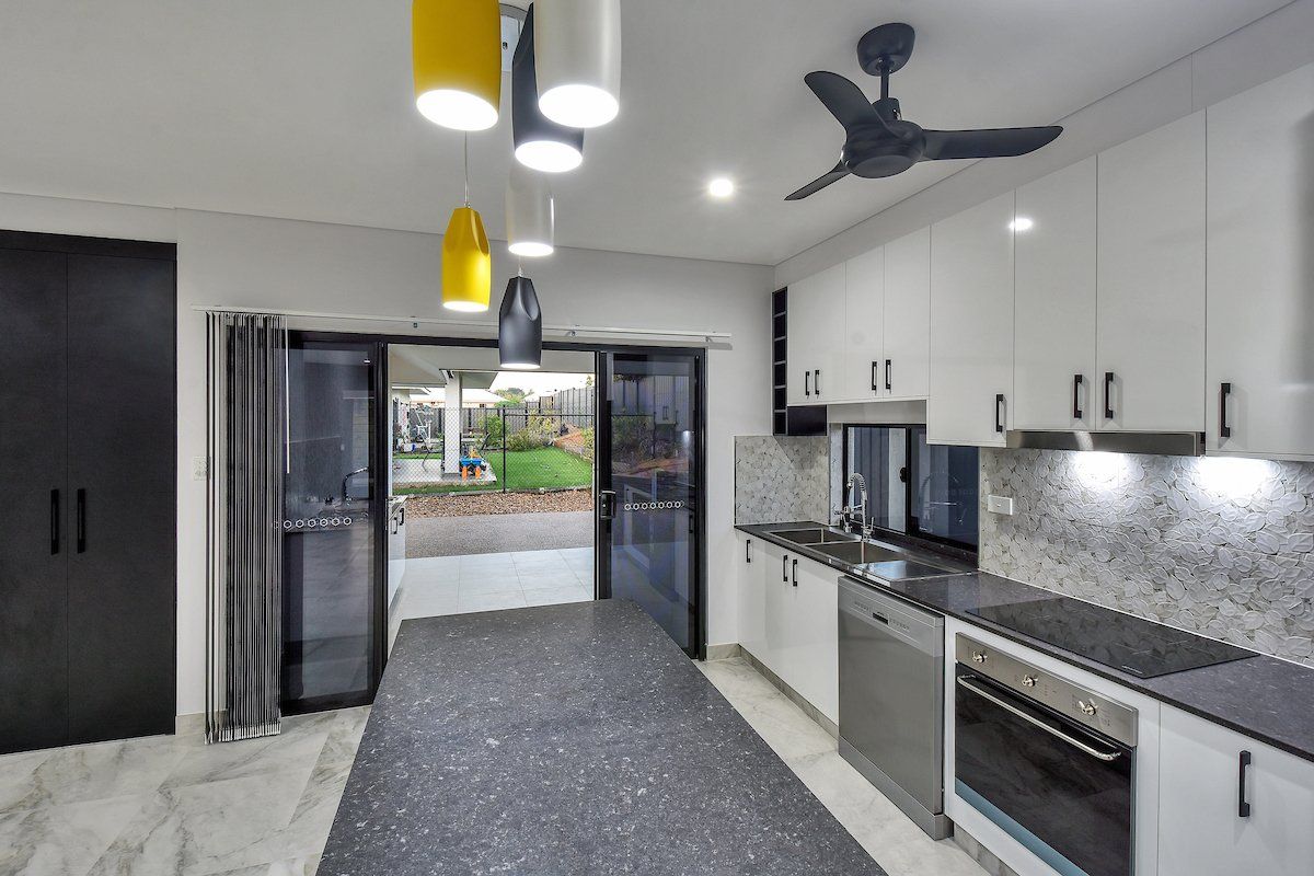 A kitchen with stainless steel appliances and a ceiling fan.