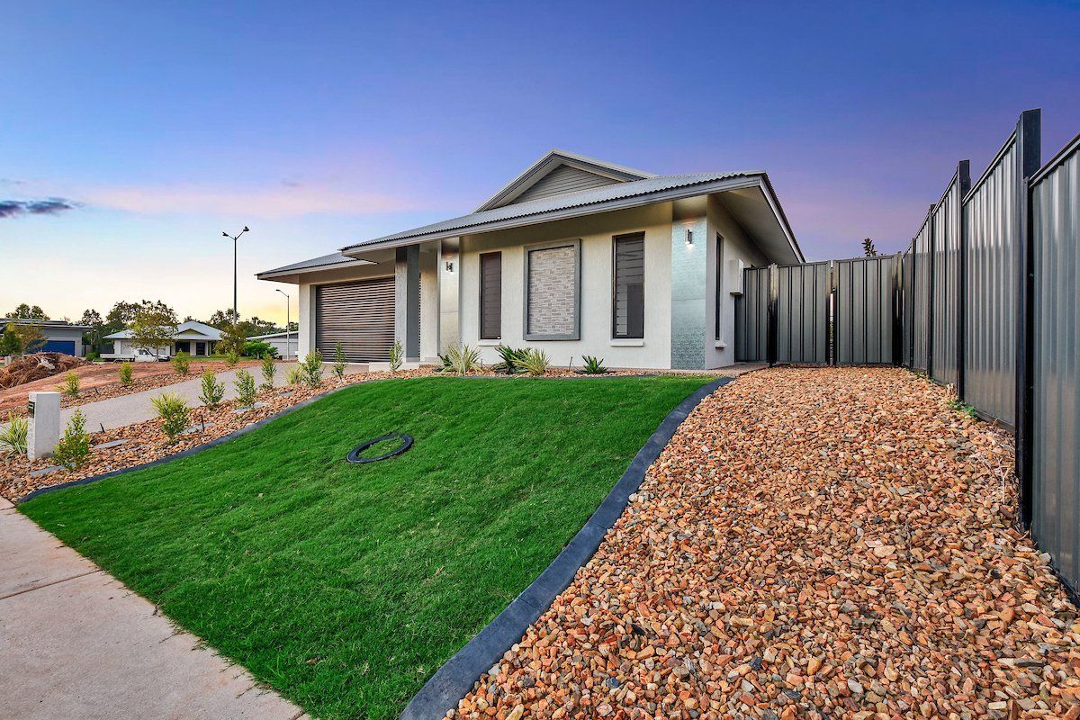 A house with a gravel driveway in front of it.