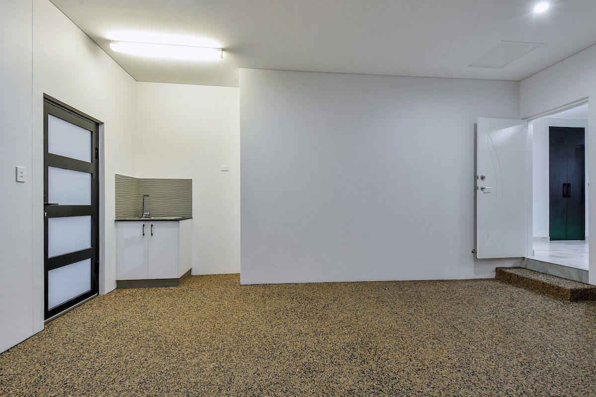 An empty room with a carpeted floor and white walls.