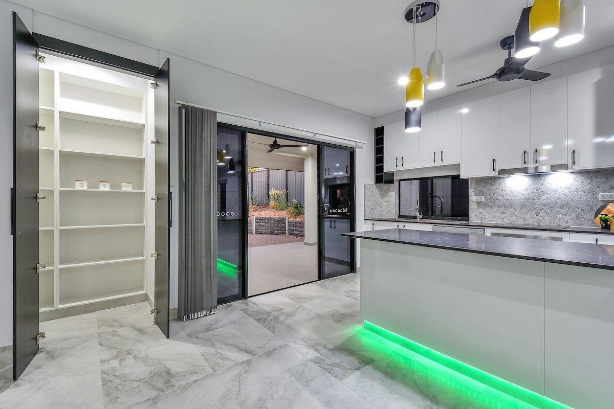 A kitchen with a green light on the counter and a pantry.