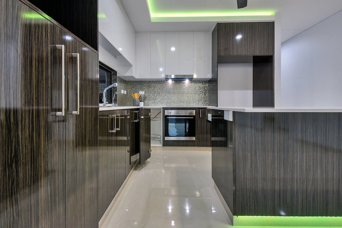 A kitchen with a lot of cabinets and a green light on the ceiling.