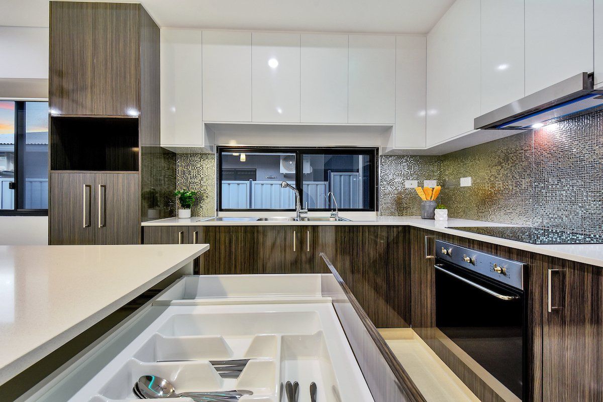 A kitchen with white cabinets and wooden cabinets