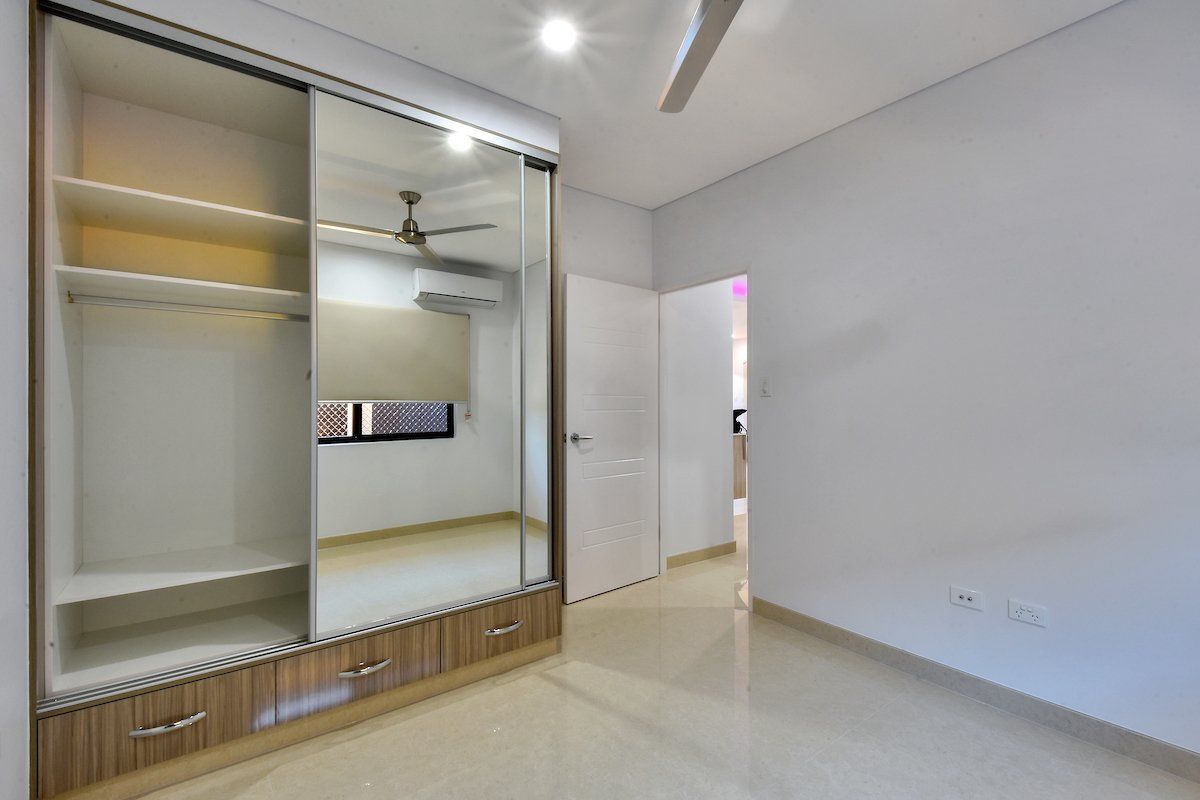 A bedroom with a ceiling fan and sliding glass doors