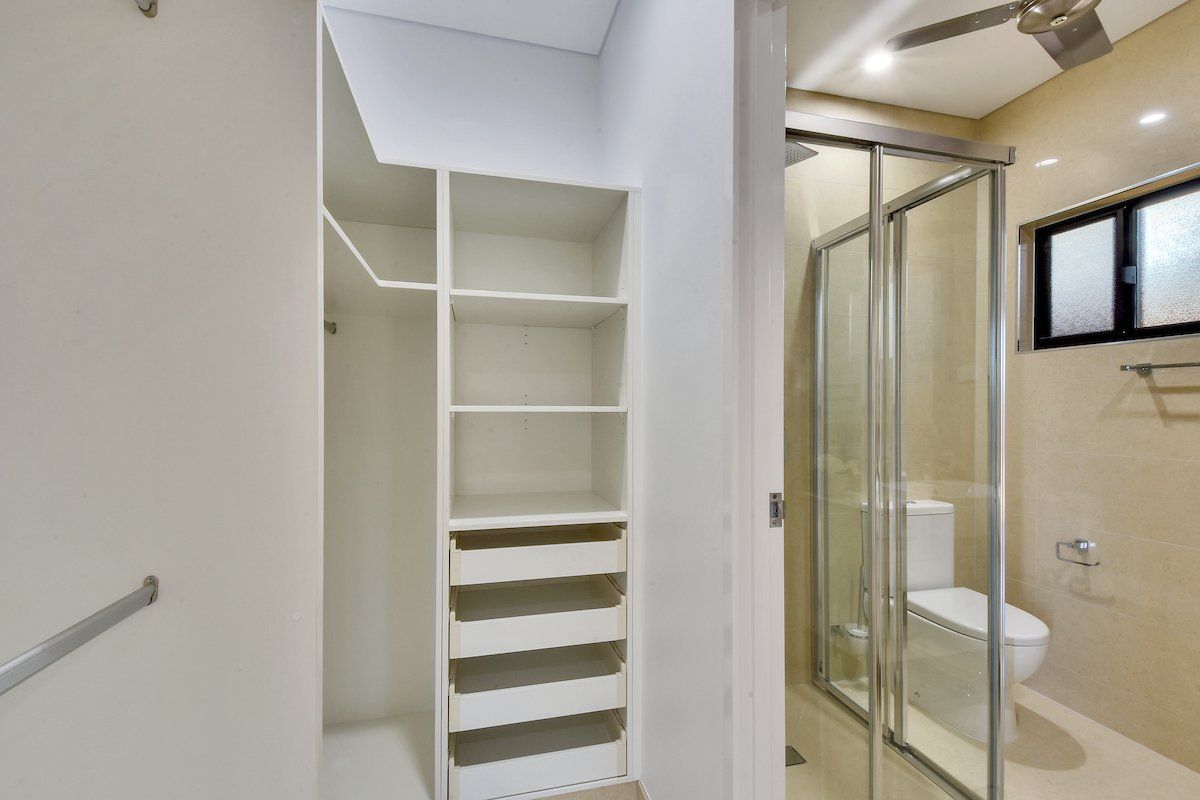 A bathroom with a walk in closet and a toilet