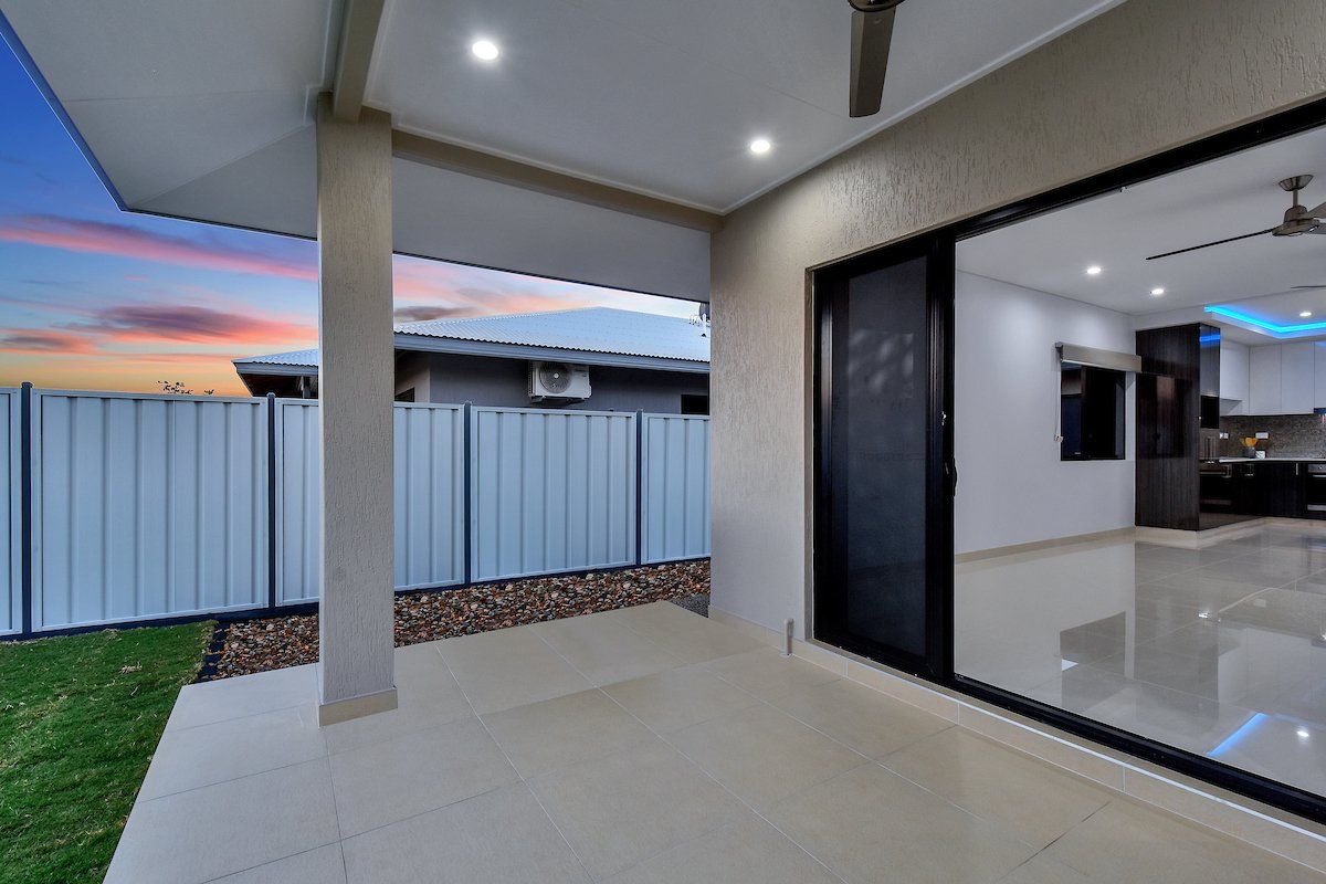 A patio with a sliding glass door and a ceiling fan in a house.