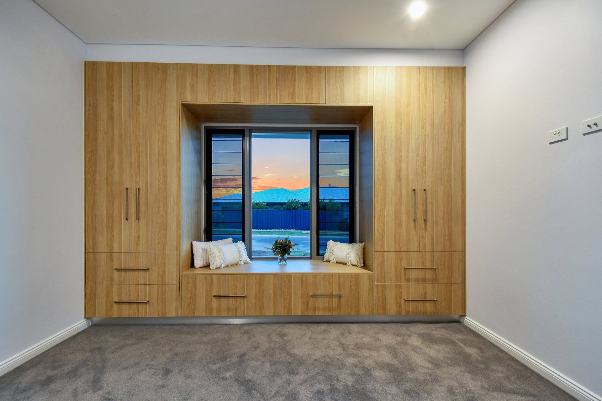 A room with a large window and lots of cabinets