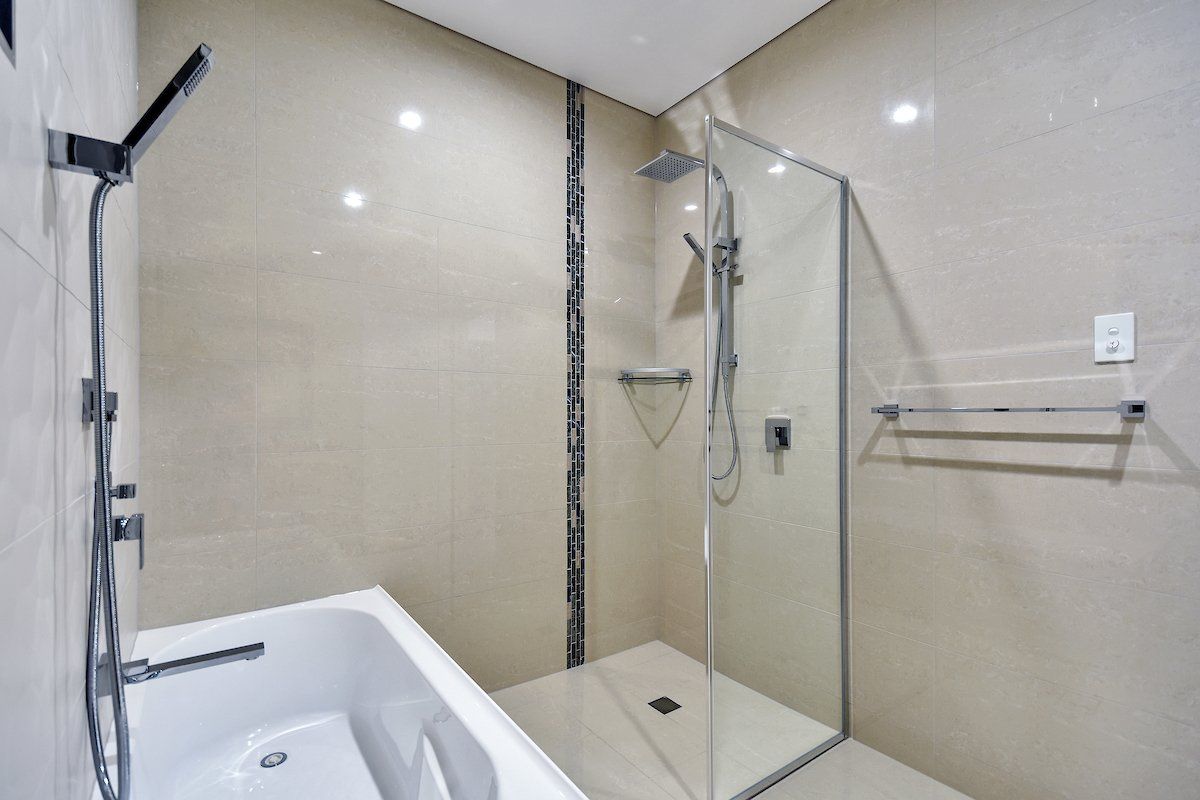 A bathroom with a bathtub and a walk in shower.