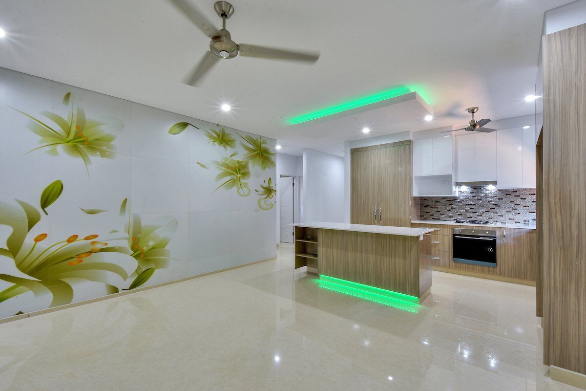 A kitchen with a ceiling fan and a floral wallpaper on the wall