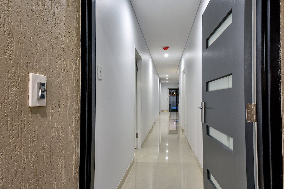 A long hallway with a door that is open
