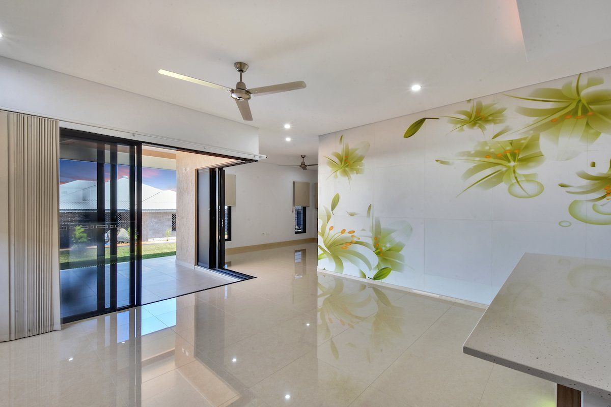 A living room with a ceiling fan and a painting on the wall.