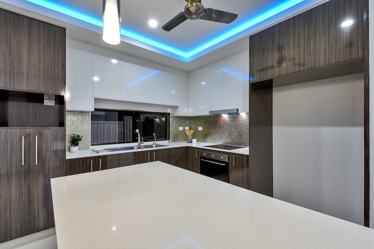 A kitchen with a large island and a ceiling fan.