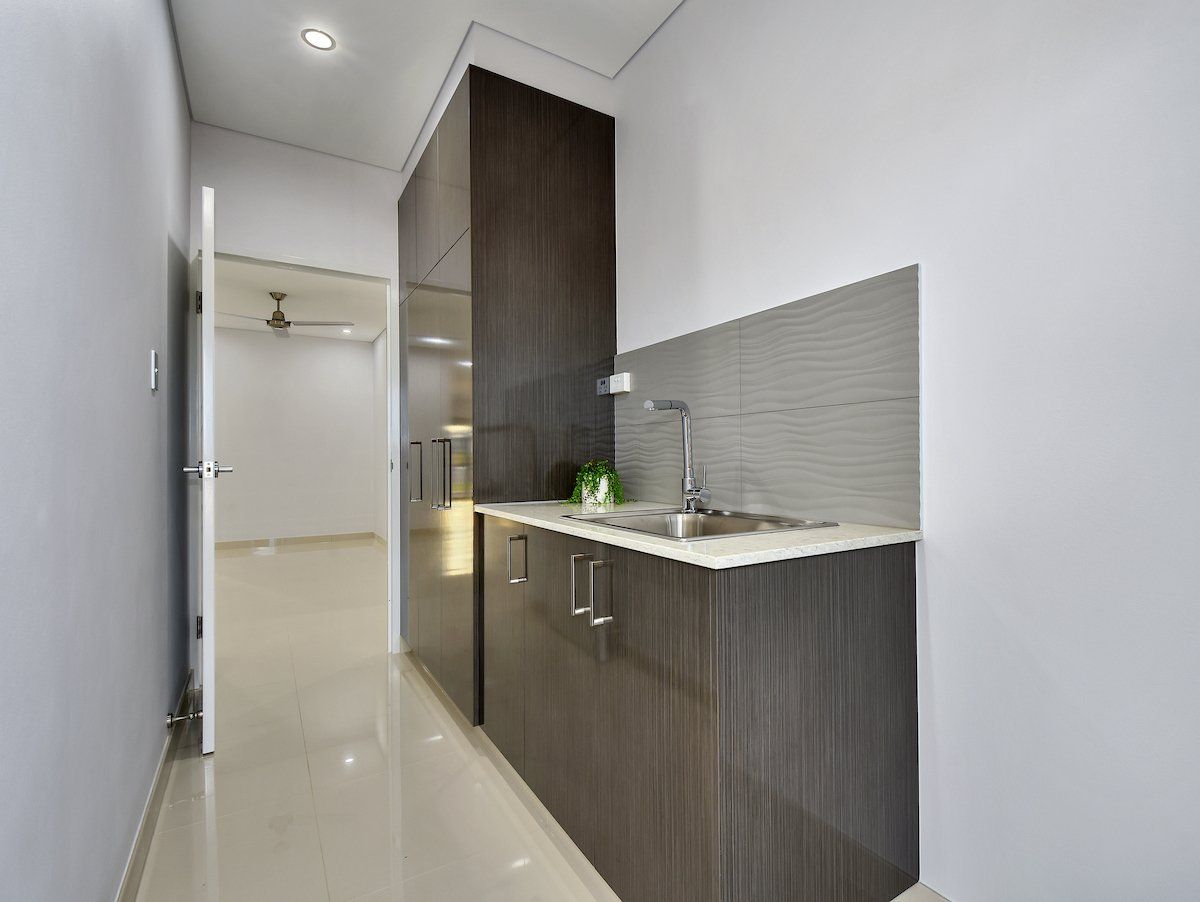 A kitchen with a sink and cabinets in a hallway