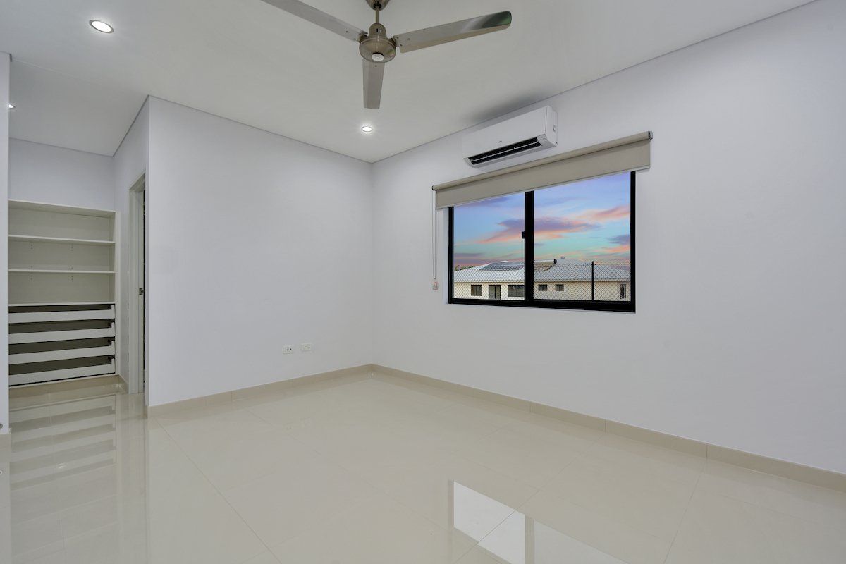 An empty room with a ceiling fan and a window.