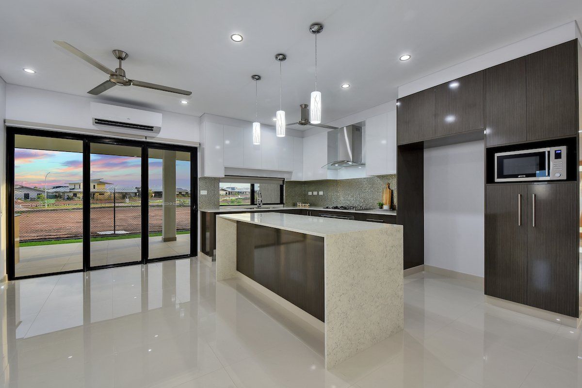 A kitchen with a large island and a ceiling fan.