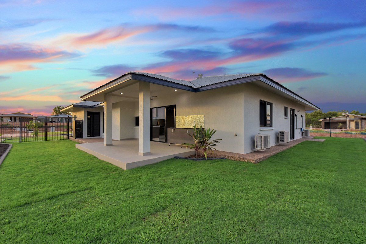 A white house with a large lawn in front of it.