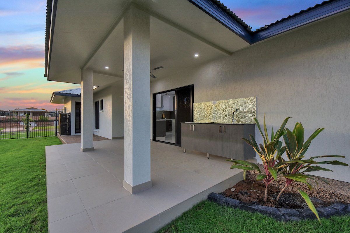 A house with a covered patio and a kitchen in the backyard.