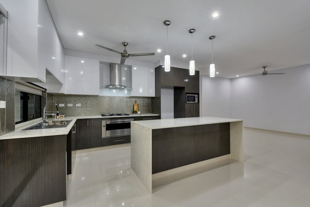 A kitchen with a large island and a ceiling fan.
