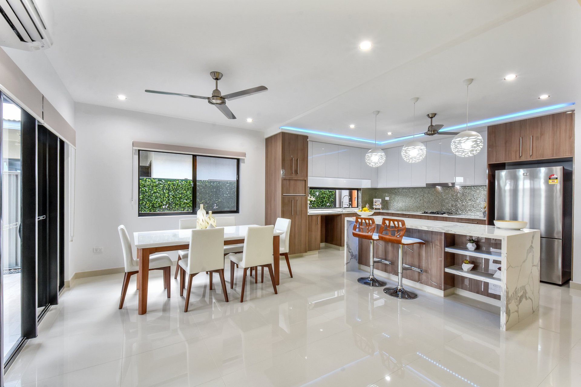 A kitchen with a table and chairs and a ceiling fan.