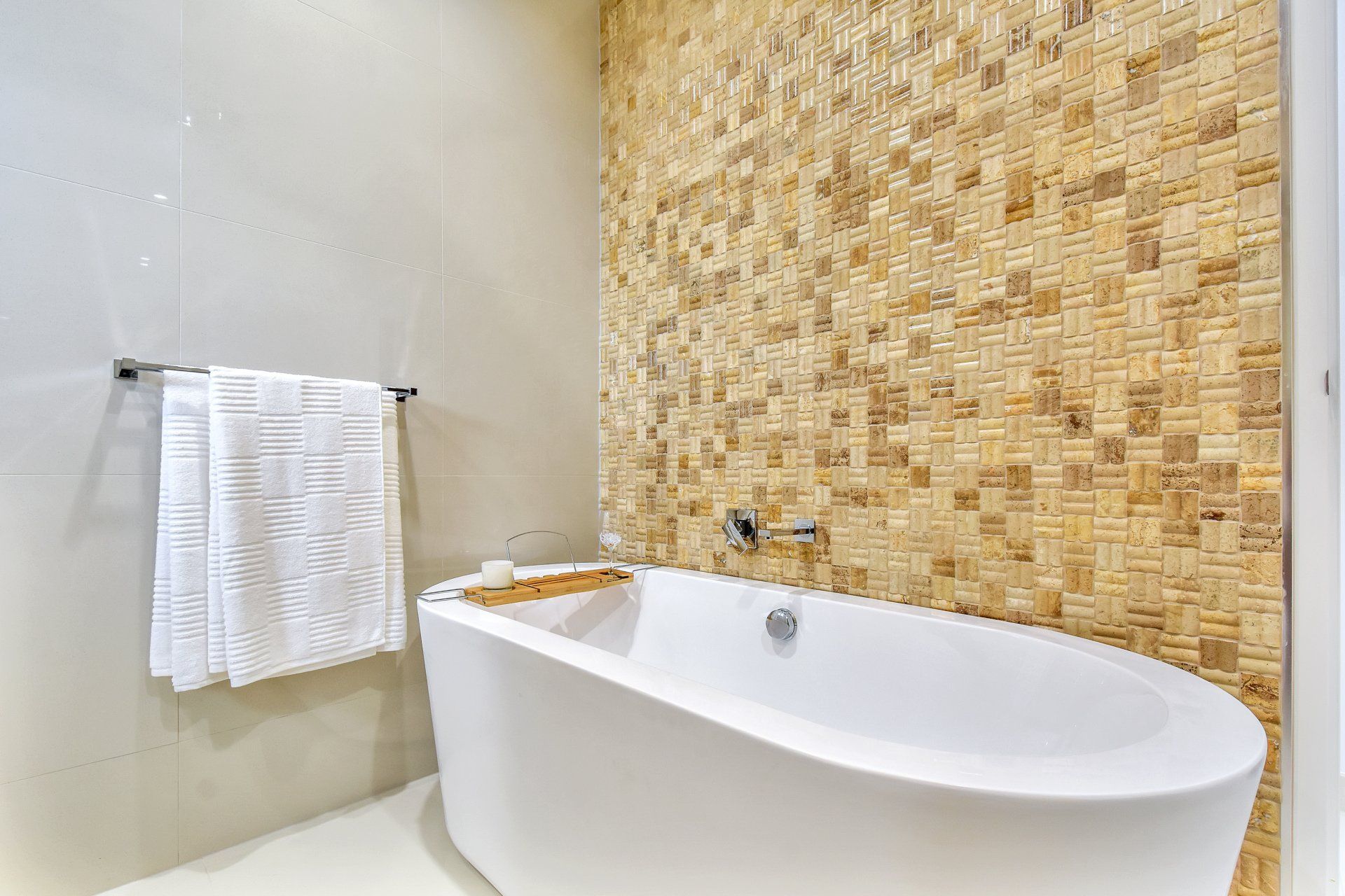 A bathroom with a bathtub and a mosaic wall.
