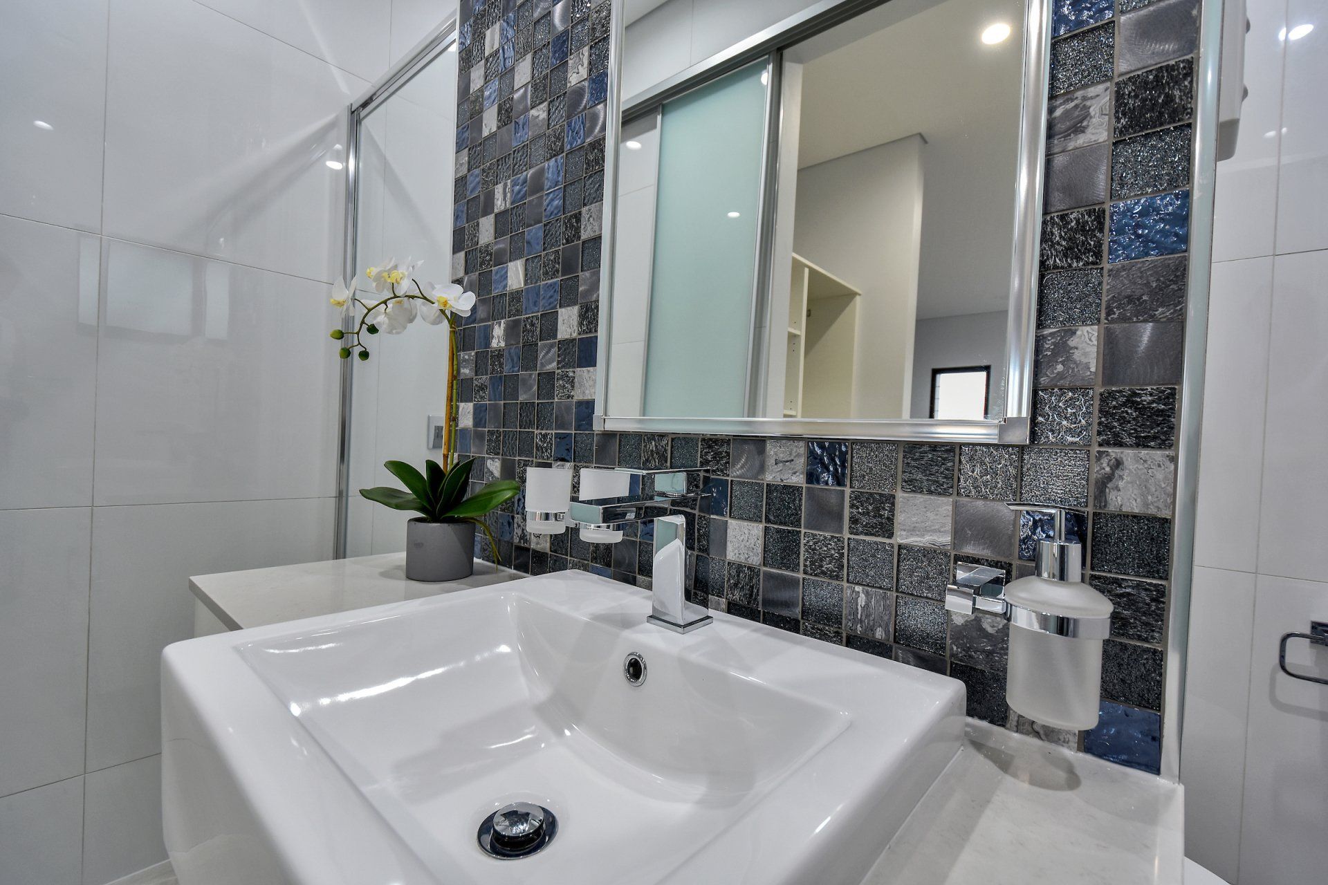 A bathroom with a sink , mirror and toilet.