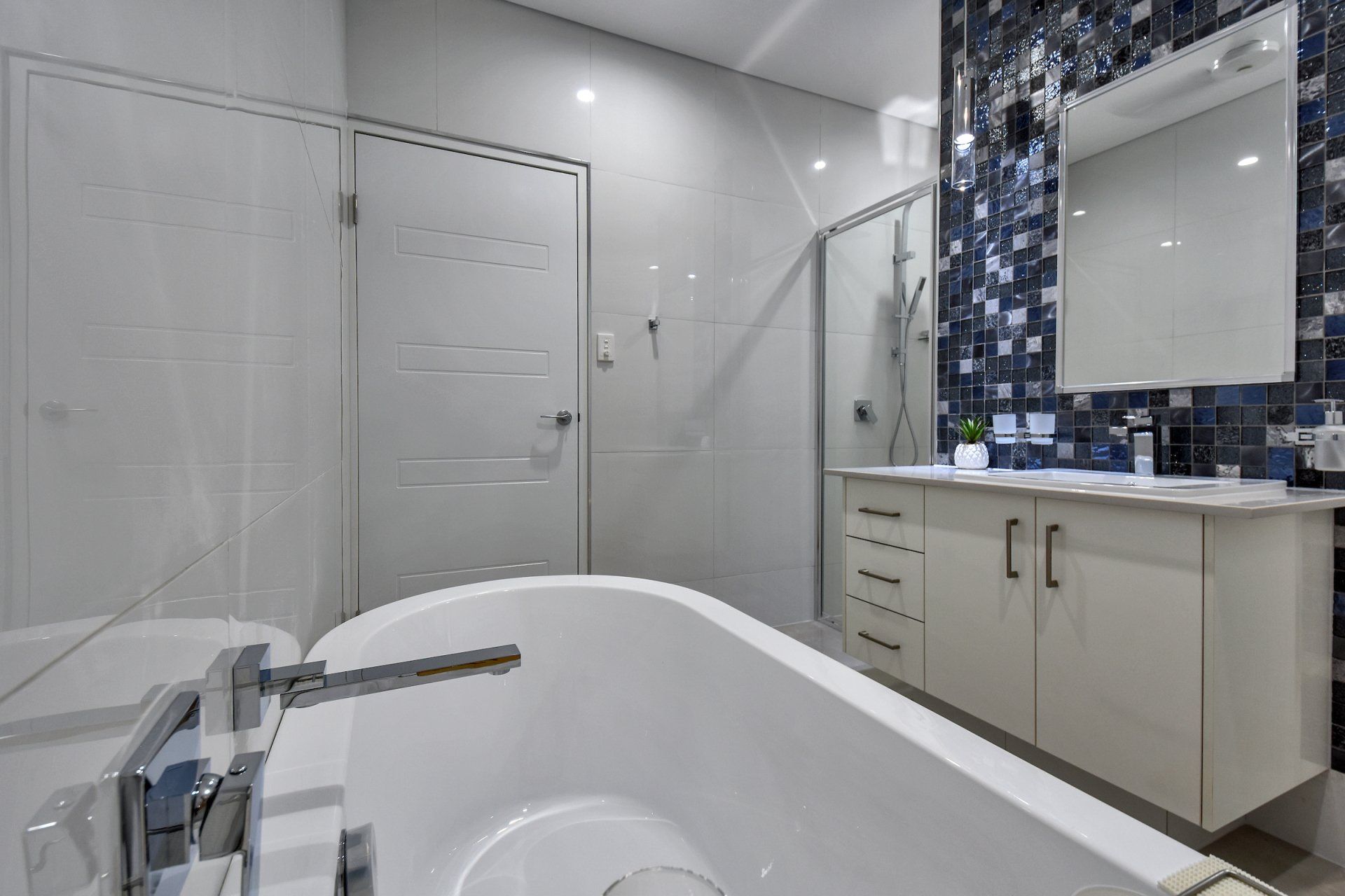 A bathroom with a bathtub , sink , mirror and shower.