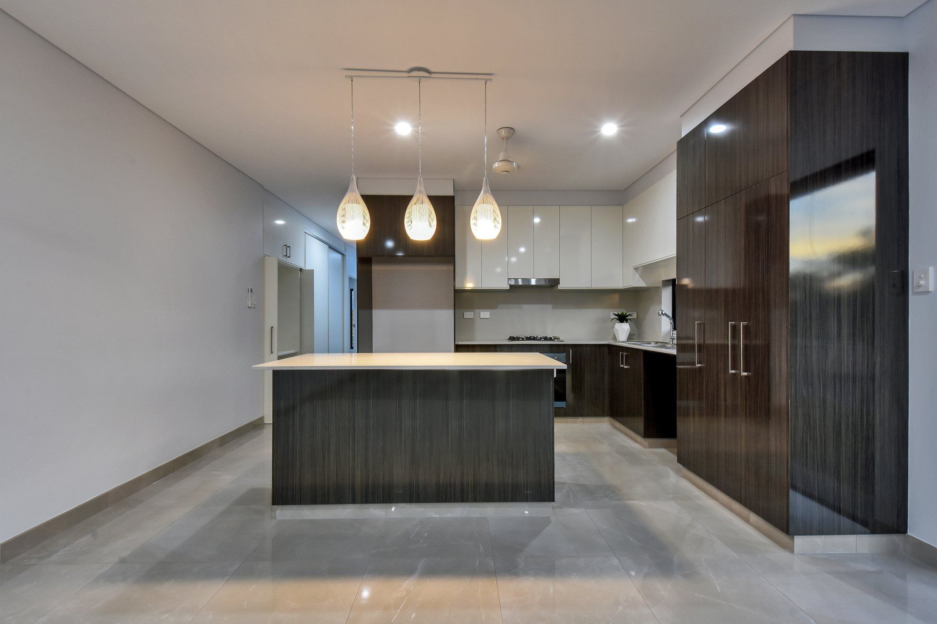 An empty kitchen with a large island in the middle