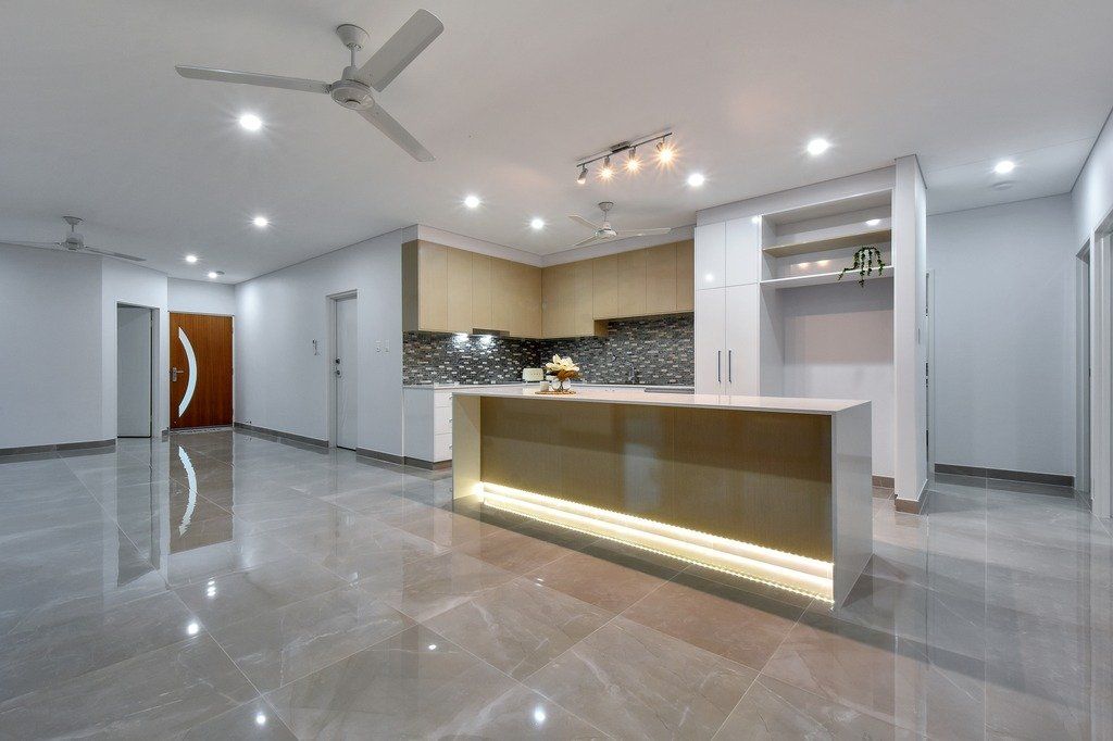 A kitchen with a large island and a ceiling fan