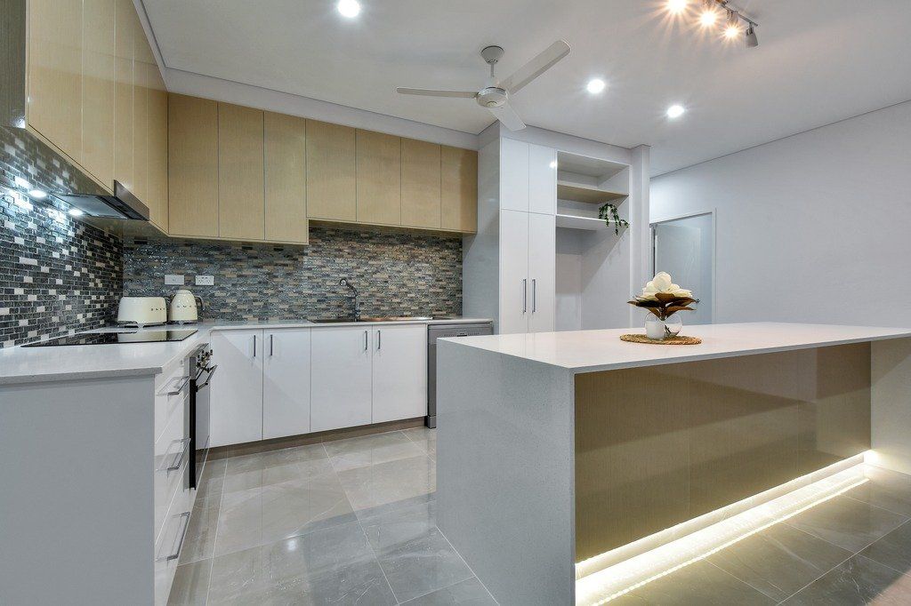 A kitchen with a large island and a ceiling fan.