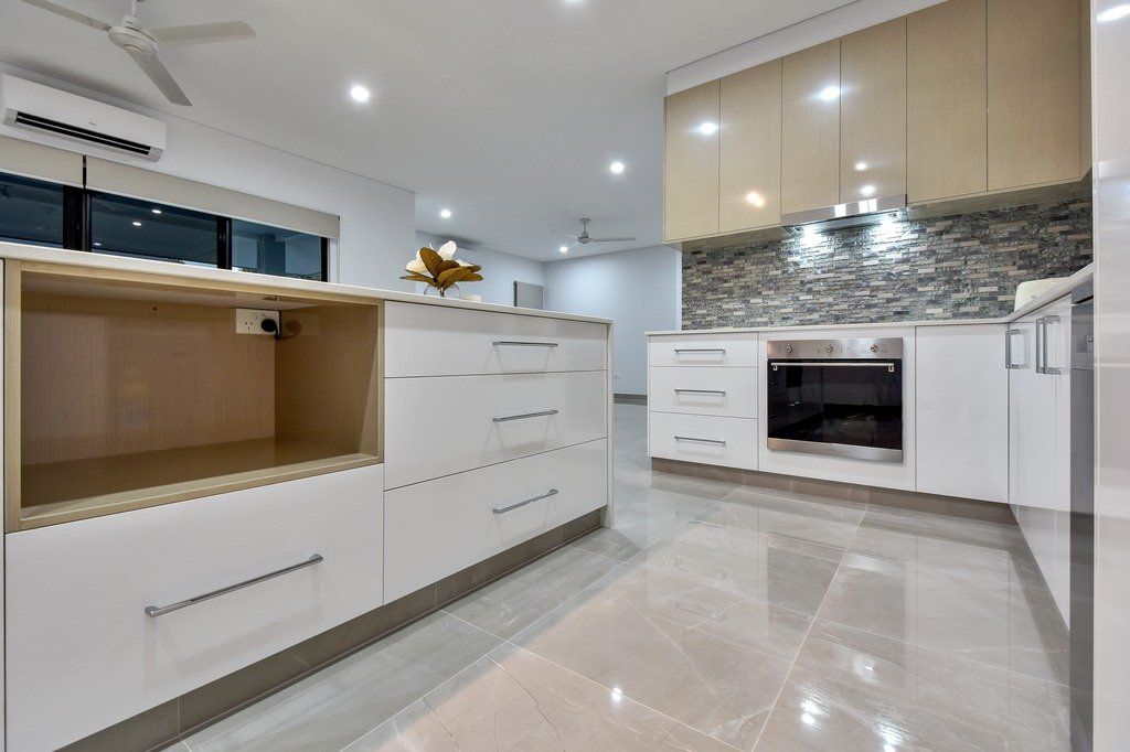 A kitchen with white cabinets and stainless steel appliances