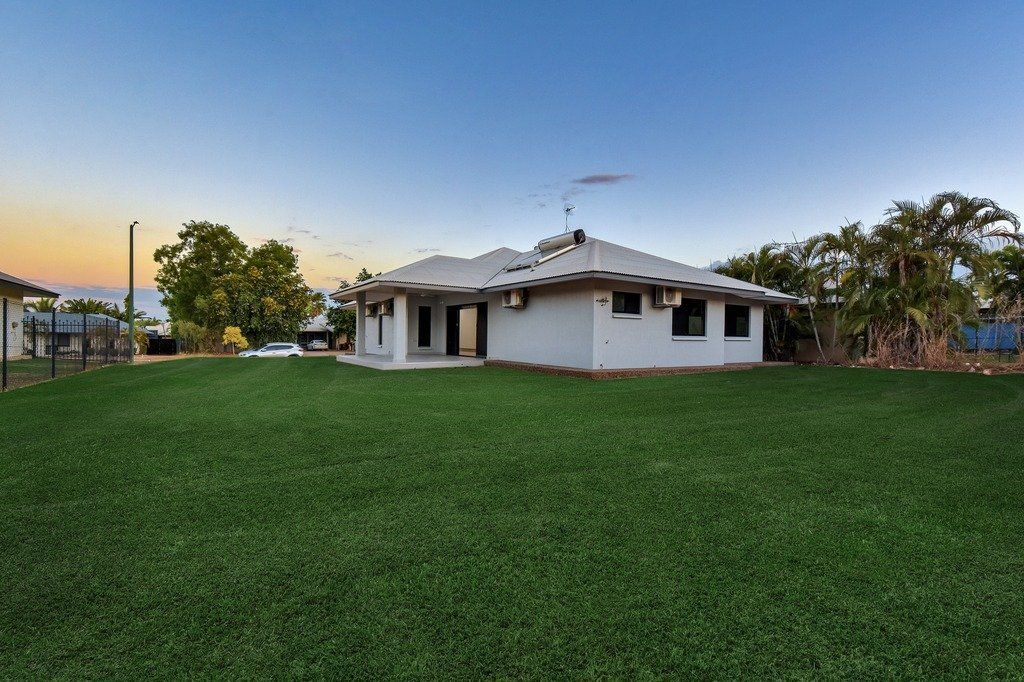 A white house with a large lawn in front of it.