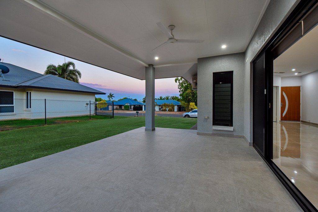 An empty patio with a ceiling fan and sliding glass doors