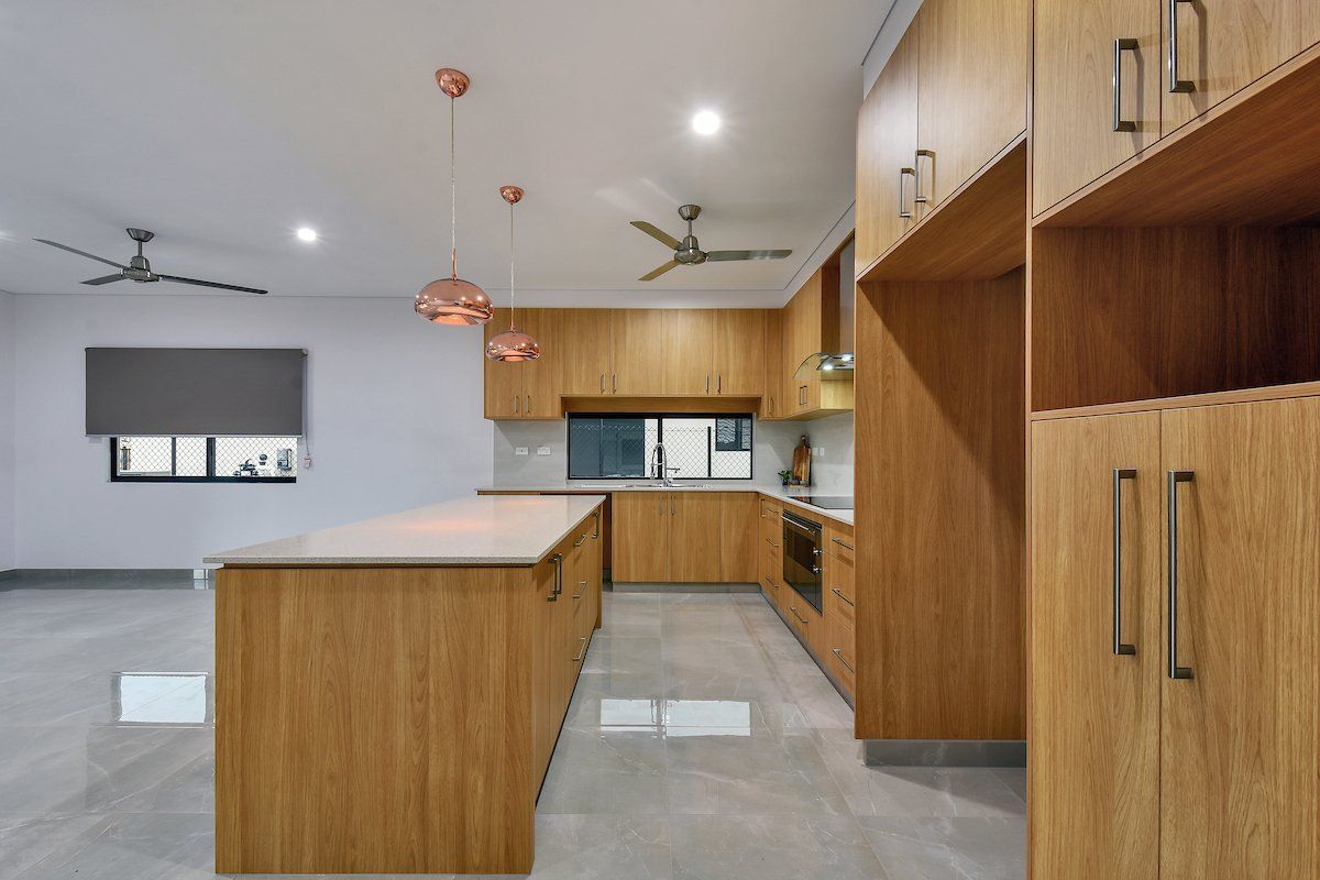 A kitchen with wooden cabinets and a large island.