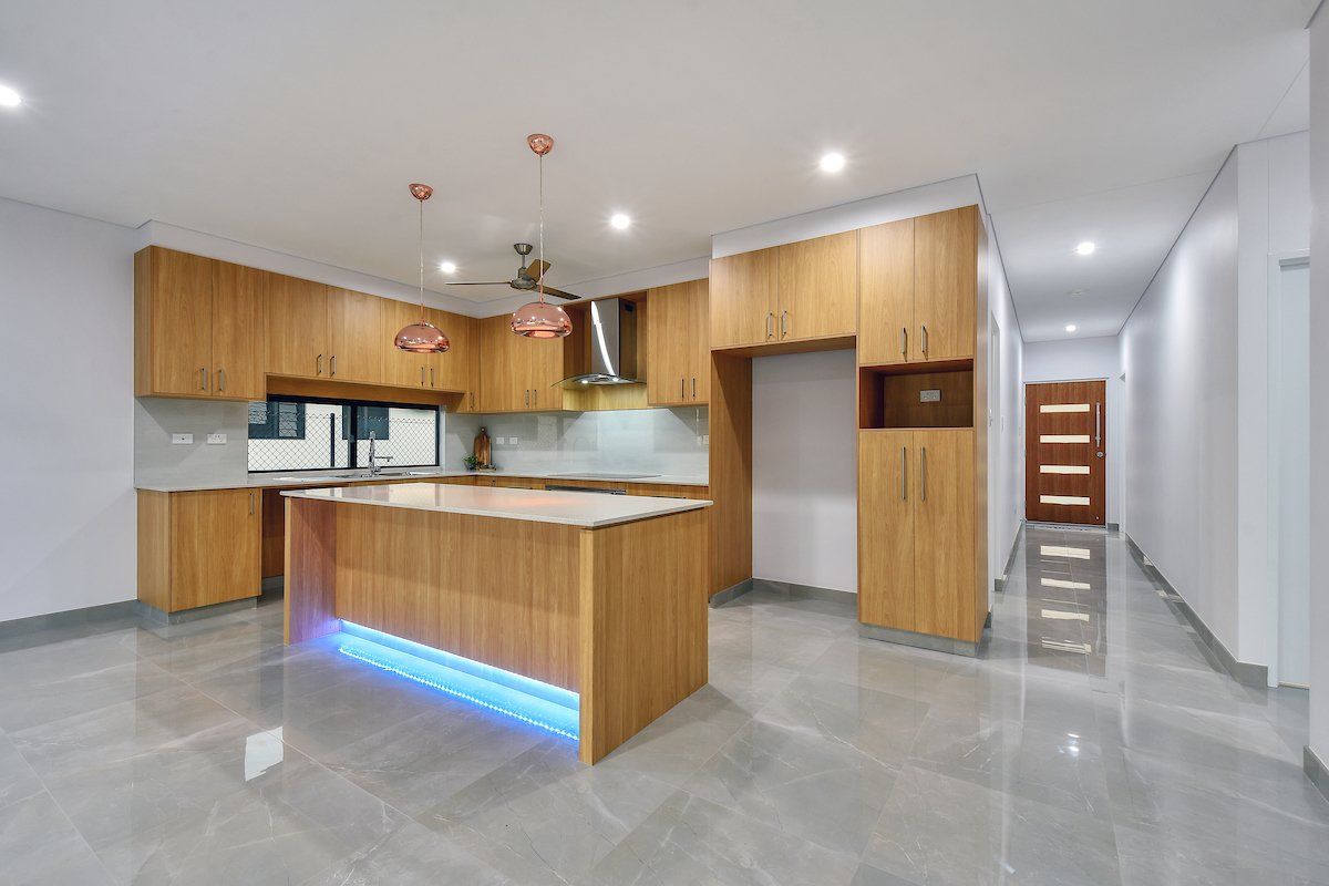 An empty kitchen with wooden cabinets and a large island.