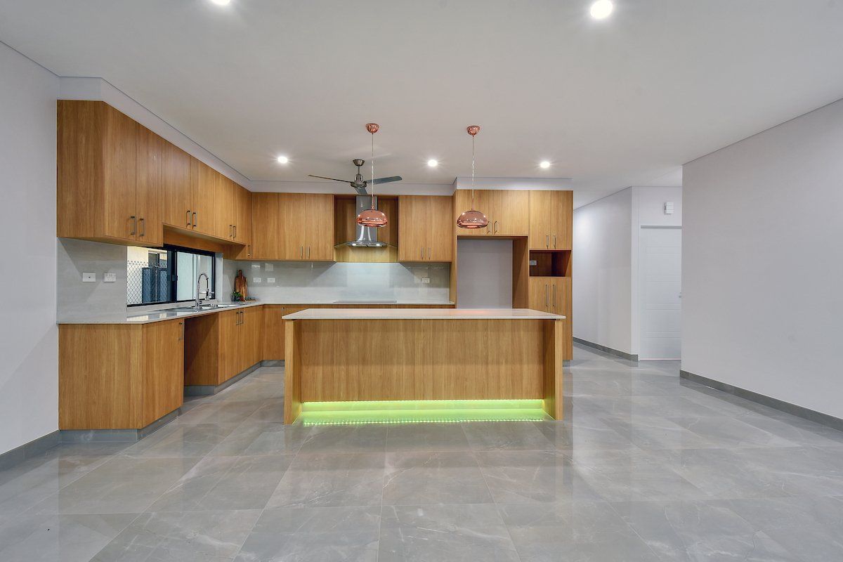 An empty kitchen with wooden cabinets and a large island.