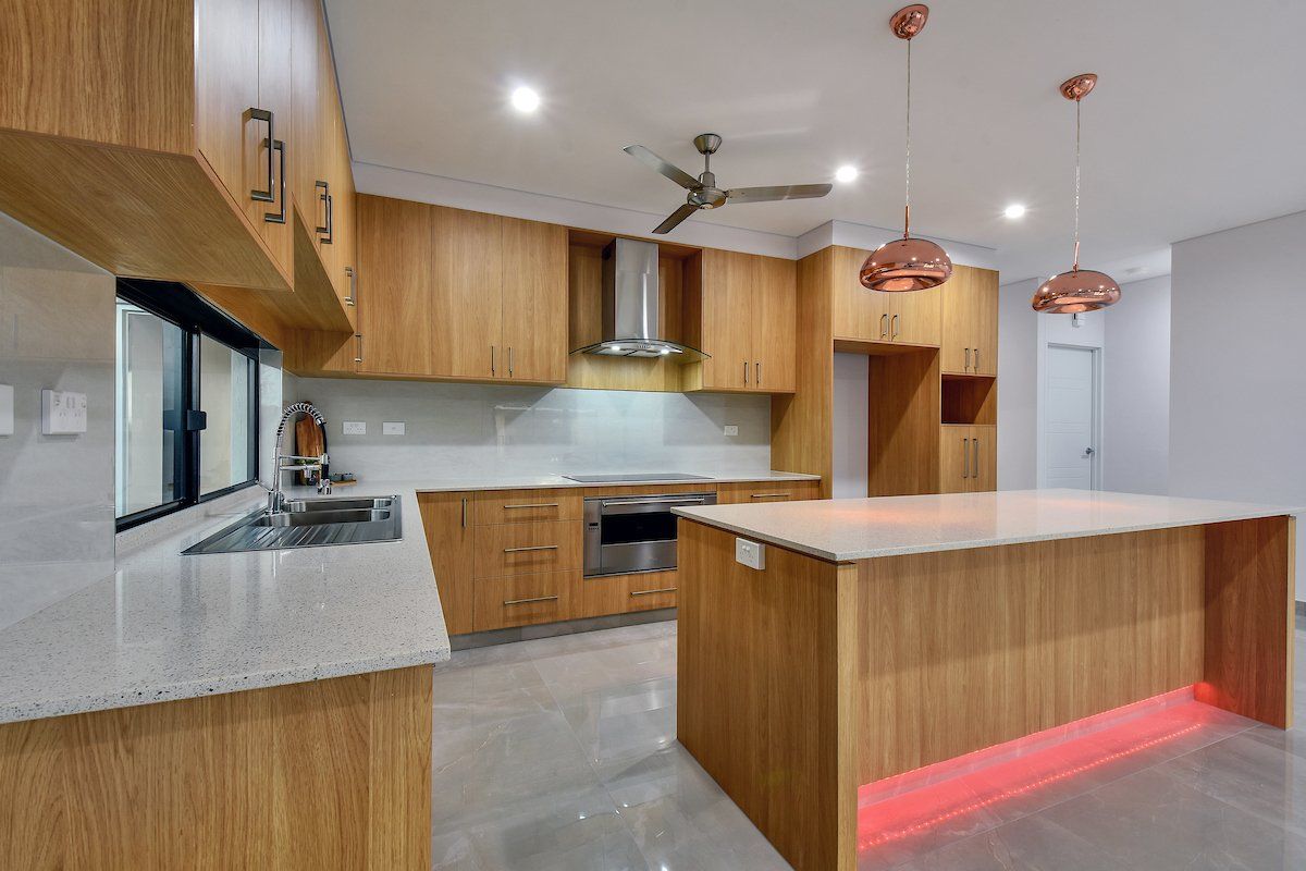 A kitchen with wooden cabinets , granite counter tops , stainless steel appliances and a large island.
