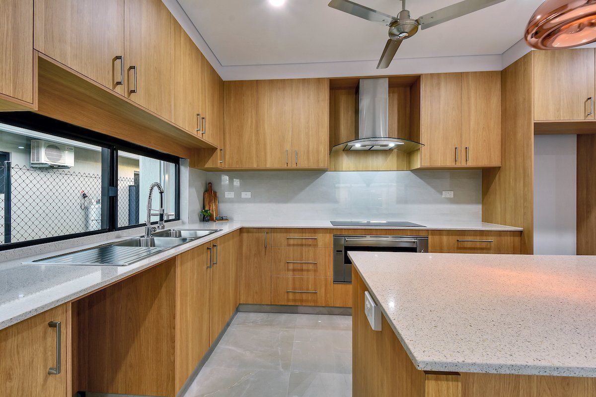 A kitchen with wooden cabinets and a ceiling fan