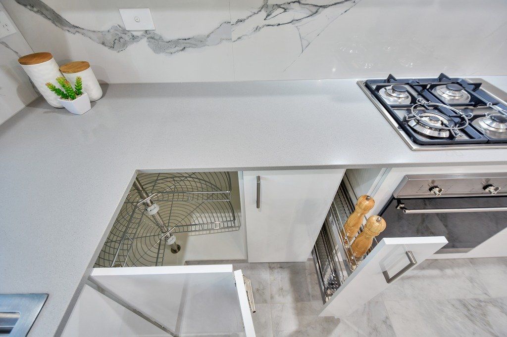 A kitchen with white cabinets and a stove top oven