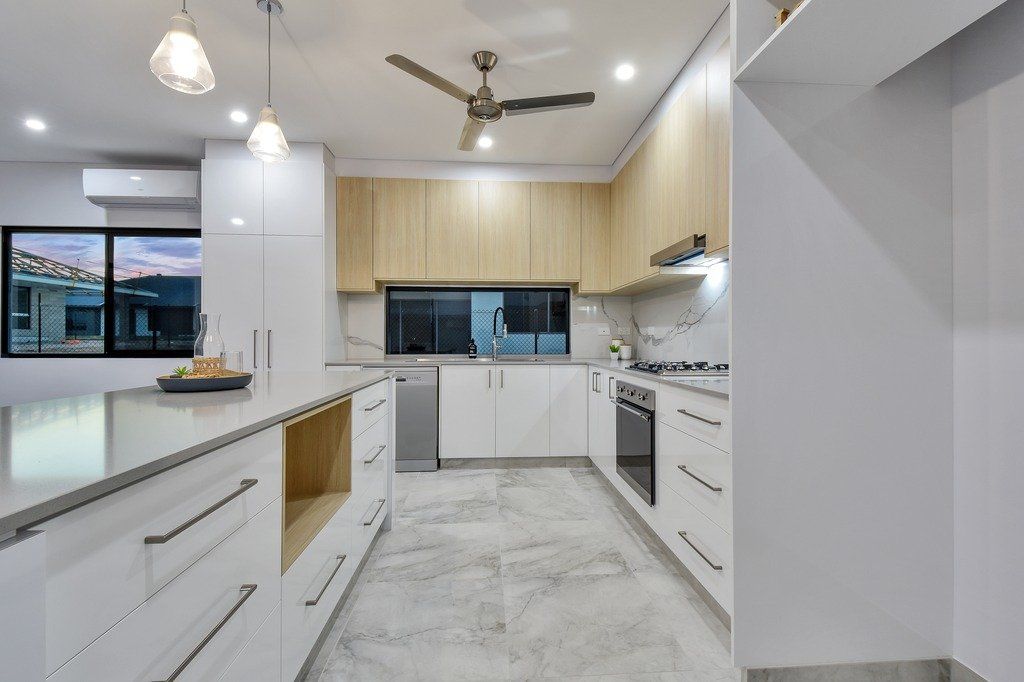 A kitchen with white cabinets and a ceiling fan