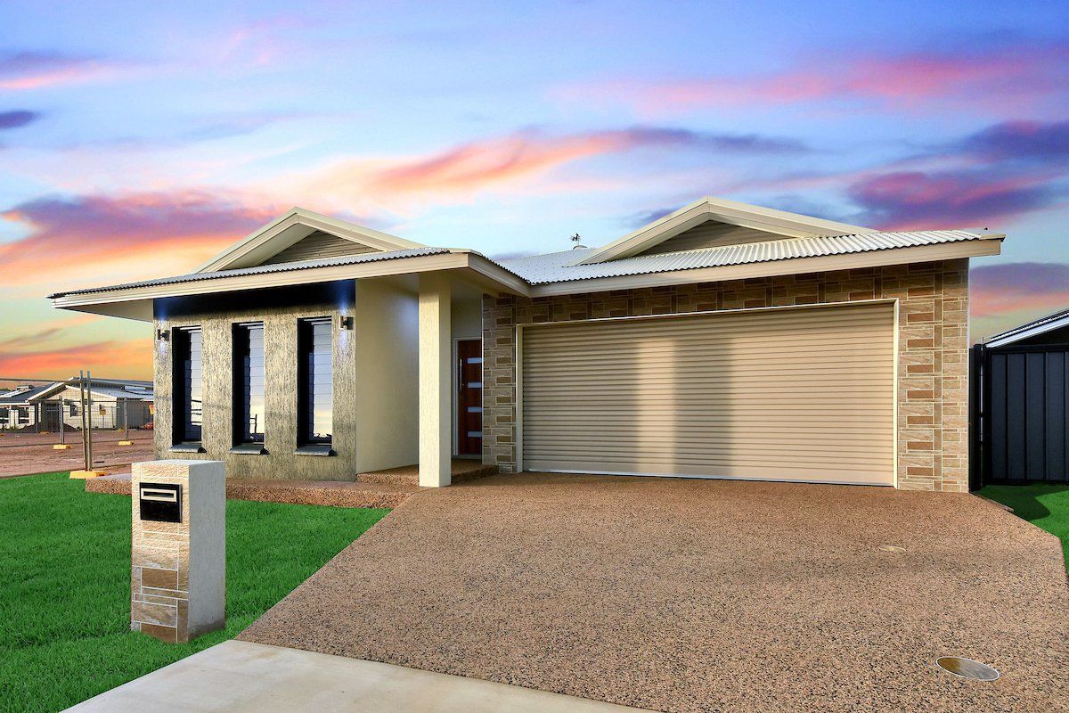 A house with a garage and a mailbox in front of it.